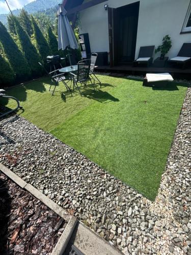 a backyard with grass and chairs and an umbrella at Jagoda in Brenna