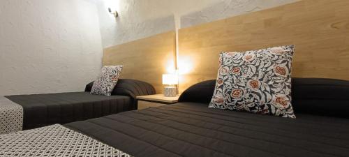 una camera con due letti e un cuscino su un letto di Casa Cueva Candelaria - Alcalá del Júcar ad Alcalá del Júcar
