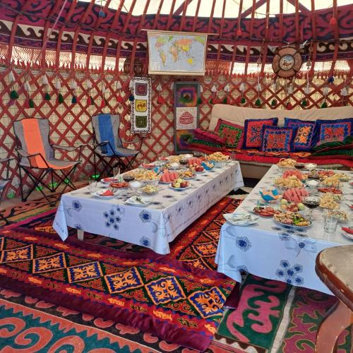 two tables in a room with plates of food at Sayakat Eco Camp in Kaji-Say