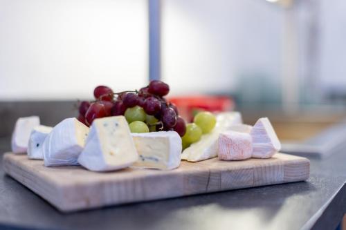 a bunch of cheese and grapes on a cutting board at Zur Alten Post in Nottuln