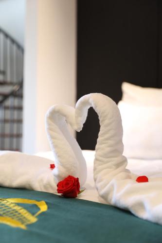 two swans made out of towels on a bed at Ao Tien Harbour Boutique Hotel in Hà Cái