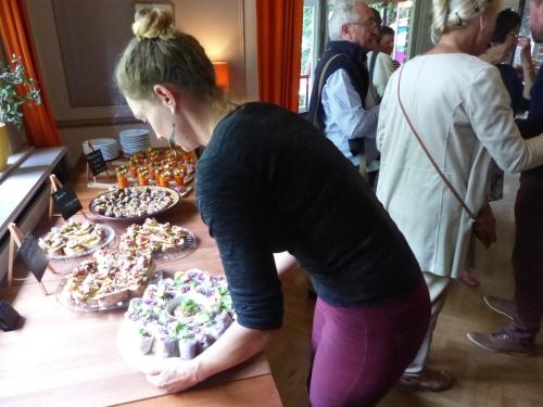 a woman is looking at a table of donuts at Arrivée - 5-Star Luxury Sports-Inspired Holiday House in Merelbeke