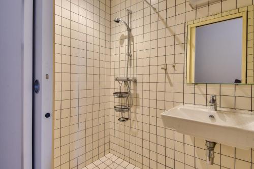 La salle de bains est pourvue de carrelage blanc, d'un lavabo et d'un miroir. dans l'établissement En plein centre de Noirmoutier en l ile - Maison pour 6, à Noirmoutier-en-l'lle