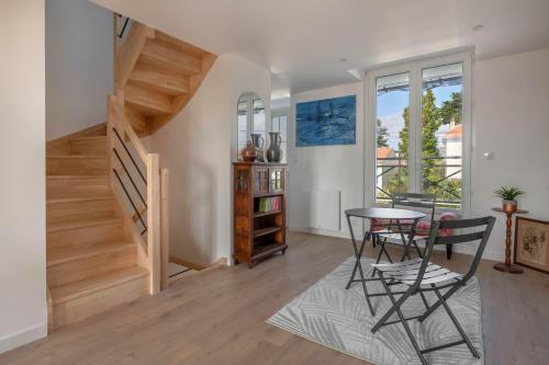 un salon avec une table et des chaises et un escalier dans l'établissement Maison familiale à 400m de la mer pour 8, Pornic, à Pornic