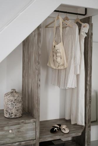 a room with a shelf with a dress and shoes at Coco-Mat Hotel Santorini in Akrotiri