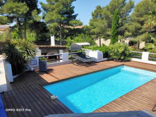 une piscine sur une terrasse en bois avec une chaise et une chaise dans l'établissement Lavocette maison appartement, au Grau-dʼAgde