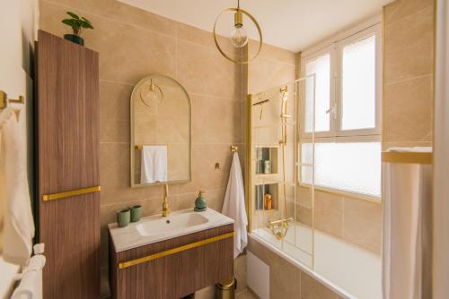 une salle de bain avec un lavabo et un miroir dans l'établissement Luxury Art Deco Elegant Escape by Eiffel Tower, à Paris