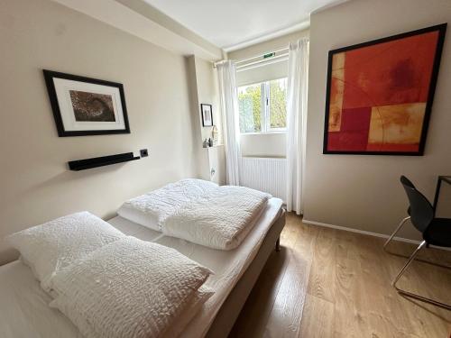 two beds in a room with a window at Apartment in Huldubraut in Kópavogur - Birta Rentals in Reykjavík