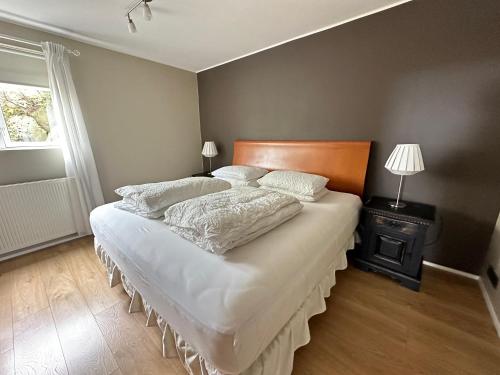 a bedroom with a large bed with white sheets and pillows at Apartment in Huldubraut in Kópavogur - Birta Rentals in Reykjavík