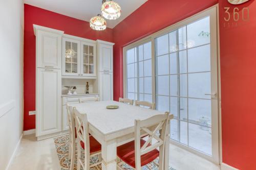 a dining room with red walls and a table and chairs at Stunning Traditional 3BR Townhouse in Siggiewi by 360 Estates in Siġġiewi