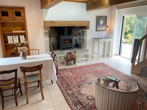 un salon avec une table et une cheminée dans l'établissement La Quinta, à Blainville-sur-Mer