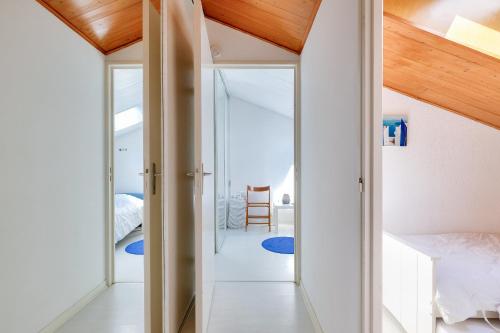 - une chambre avec des murs blancs et un plafond en bois dans l'établissement Maison pour 6 proche plage, lac et zoo, à Les Sables-dʼOlonne