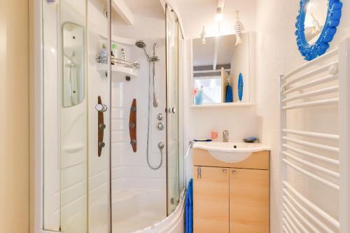 une salle de bain avec douche et lavabo dans l'établissement Maison pour 6 proche plage, lac et zoo, à Les Sables-dʼOlonne