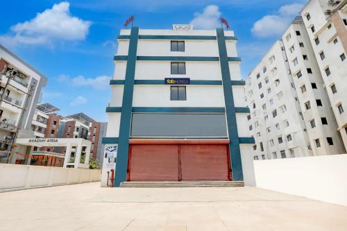 a tall white building with a red garage at FabHotel Prime Ace II - Near Jupiter Hospital in Vadodara