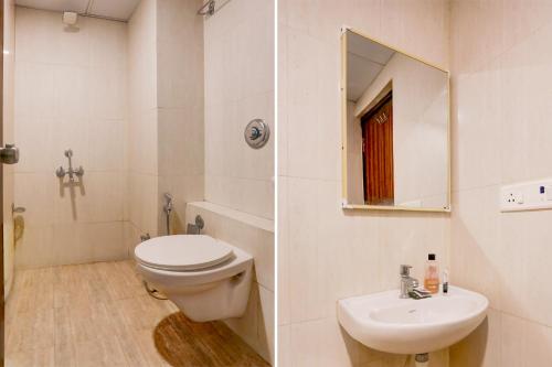 a bathroom with a toilet and a sink and a mirror at FabHotel Prime Ace II - Near Jupiter Hospital in Vadodara
