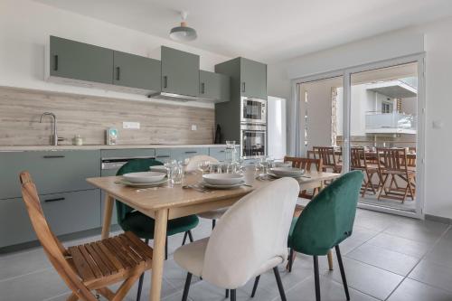 une cuisine et une salle à manger avec une table et des chaises en bois dans l'établissement Rez-de-terrasse pour 6 proche centre de Pornic, à Pornic