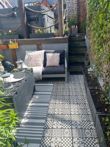 a patio with a couch and a table and stairs at Coastal Joy - Room 1 in Newbiggin-by-the-Sea