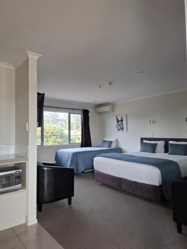 um quarto de hotel com duas camas e uma janela em Aveda Motor Lodge em Pukekohe Este
