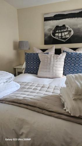 a large bed with white sheets and blue pillows at Bala Holiday Suites in Bala
