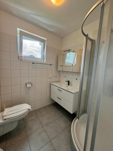 a bathroom with a toilet and a sink and a shower at Apartment Studio & Family - Adler Resort in Kaprun