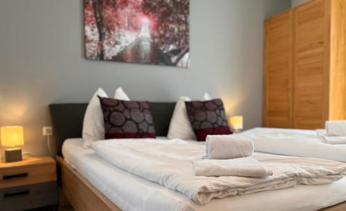 a bedroom with two beds and a painting on the wall at Apartment Studio & Family - Adler Resort in Kaprun