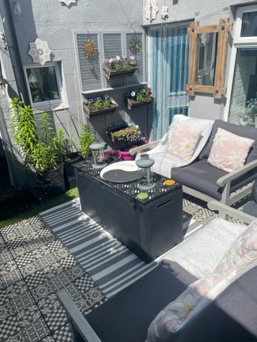 a patio with a couch and a chair on a porch at Coastal Joy - Room 4 in Newbiggin-by-the-Sea