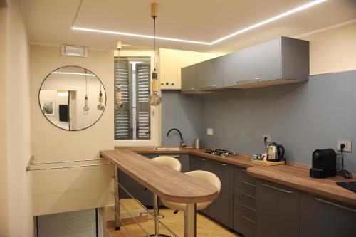 a kitchen with a counter with a sink and a mirror at Mom Apartment Rooms&Suites in Tivoli
