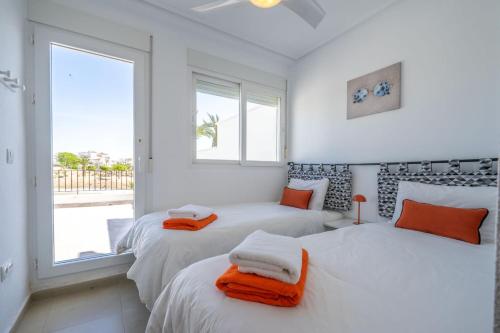 two beds in a room with two windows at Modern 3 bedroom Town House MA14LT in Torre-Pacheco