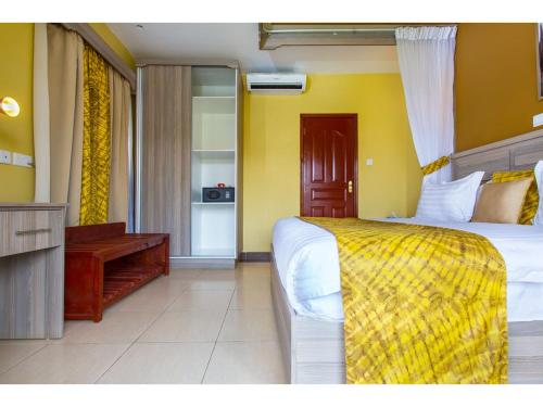a bedroom with a bed and a desk in a room at Wigot Gardens Hotel in Kisumu