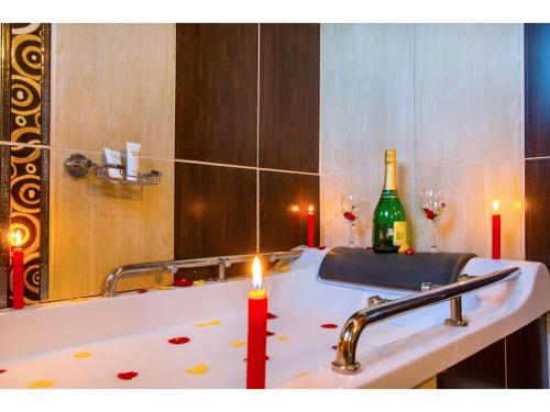 a candle on a bathroom sink with a bottle of wine at Wigot Gardens Hotel in Kisumu