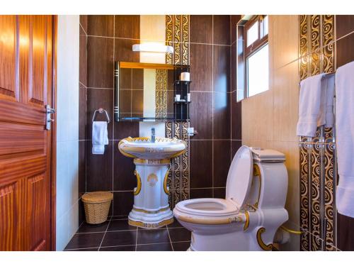a bathroom with a toilet and a sink at Wigot Gardens Hotel in Kisumu
