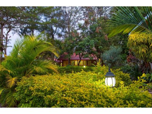 a garden with a light in front of a house at Wigot Gardens Hotel in Kisumu
