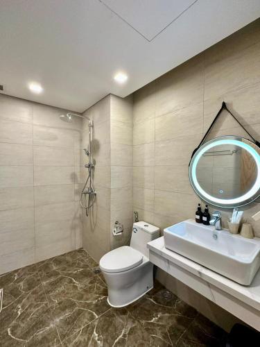 a bathroom with a toilet and a sink and a mirror at Tony Apartment -FLC Sea Tower Quy Nhon in Quy Nhon