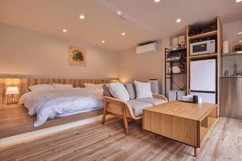 um quarto com uma cama, uma cadeira e uma mesa em SEN.RETREAT CHIKATSUYU em Tanabe