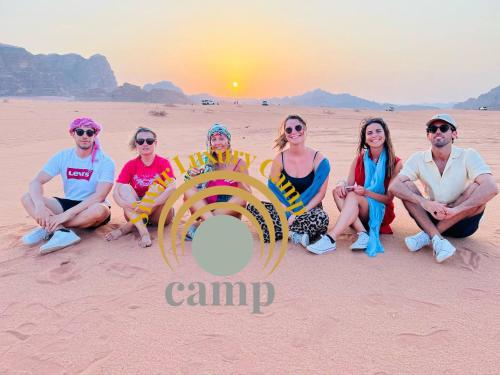 a group of people sitting in the desert at Siwar Luxury Camp in Wadi Rum