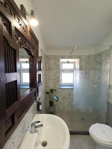 a bathroom with a sink and a shower and a toilet at Appartamento Ferdinando - Relax & Style in Caserta