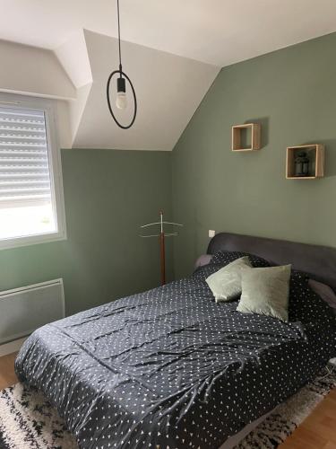 - une chambre avec un lit doté d'une couette noire et d'une fenêtre dans l'établissement La vallée, à Saint-Malo