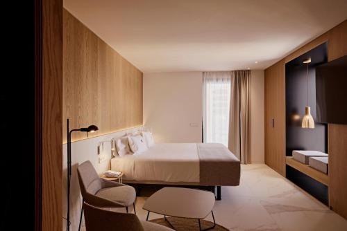 a hotel room with a bed and a chair at Core Ibiza Town Hotel in Ibiza Town