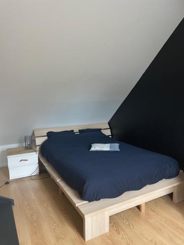 - un lit avec un cadre en bois dans une chambre dans l'établissement La vallée, à Saint-Malo