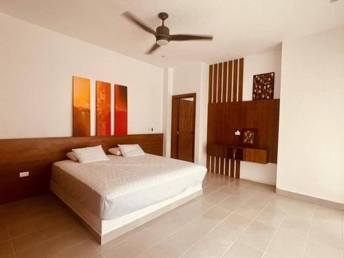 a bedroom with a bed and a ceiling fan at Casa nueva, moderna vista al mar in Carrizal
