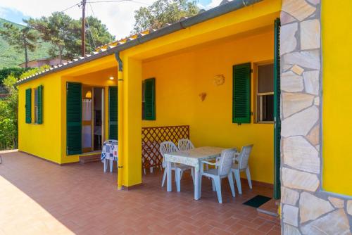 a yellow house with a table and chairs on a patio at Appartamento Il Mare Dalla Terrazza in Rio nellʼElba