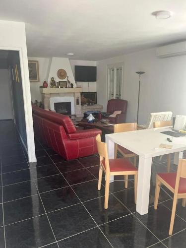 un salon avec un canapé rouge et une table dans l'établissement Maison charmante à Marseillan avec grand jardin et terrasse, à Marseillan