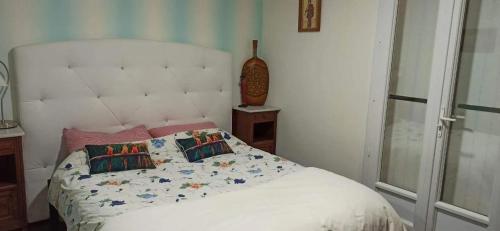 - une chambre avec un lit blanc et des oreillers dans l'établissement Maison charmante à Marseillan avec grand jardin et terrasse, à Marseillan