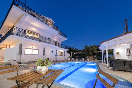 a villa with a swimming pool and a house at Denise Studios and Apartments in Argasi