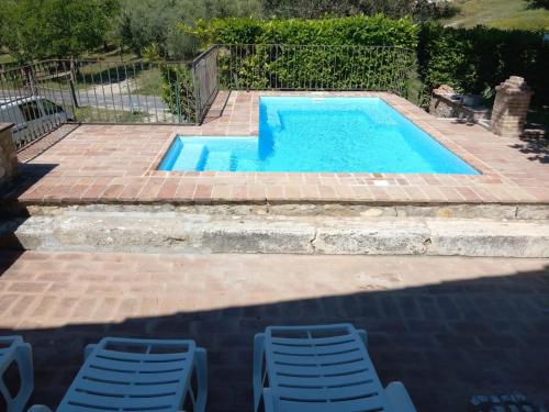 a swimming pool with two chairs and a table at B&B I Montanari in Itieli