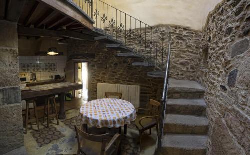 Zimmer mit einem Tisch und einer Treppe in einem Gebäude in der Unterkunft Hotel Rural Bermellar in Bermellar