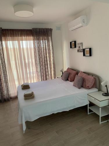 a bedroom with a large white bed and a window at Terrace Room on Parish Street in Luqa