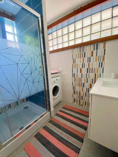une salle de bain avec douche et machine à laver dans l'établissement Royan Villa 1970, à Royan