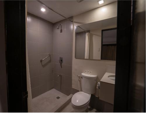 a bathroom with a toilet and a shower and a sink at GT Hotel Jaro in Iloilo City