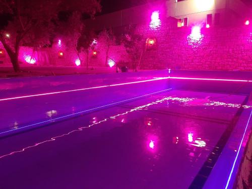 einen Pool mit violetten Lichtern auf einer Straße in der Unterkunft Floger world in Vlorë